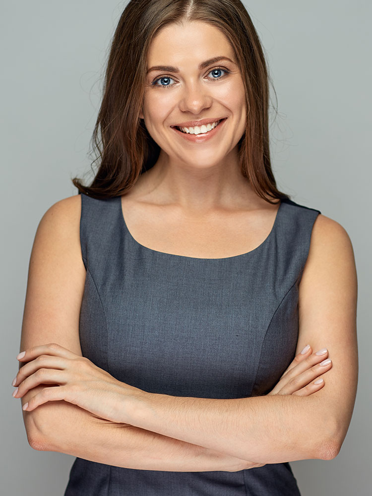 A happy woman in a grey cocktail dress crossing her arms