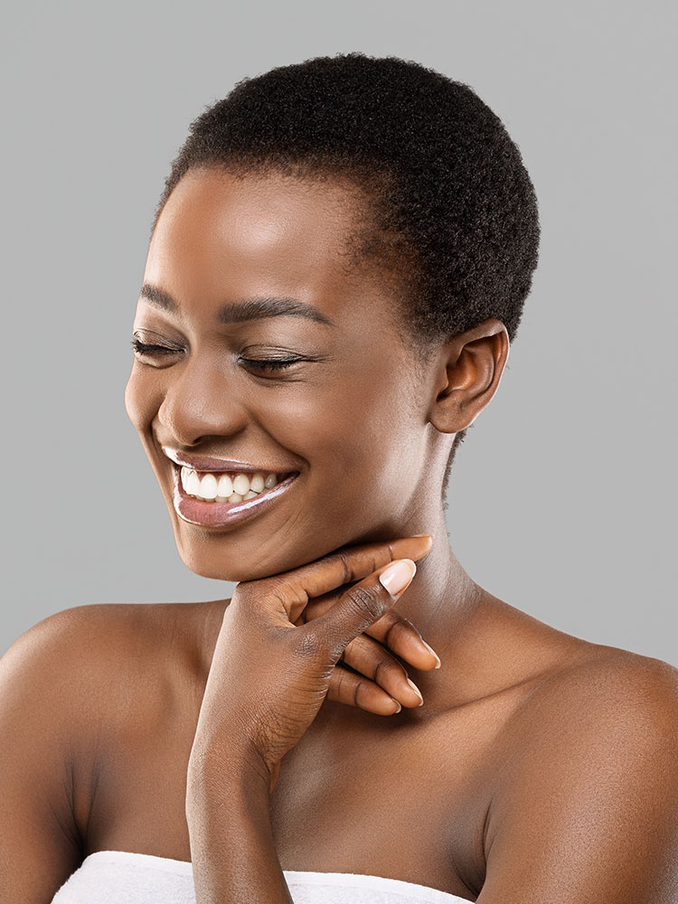 Headshot of a woman smiling wearing a white towel