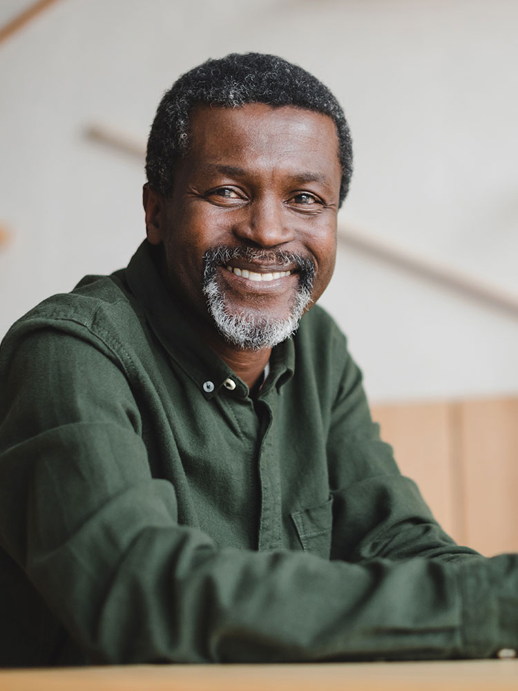 Headshot of an older man leaning on a table